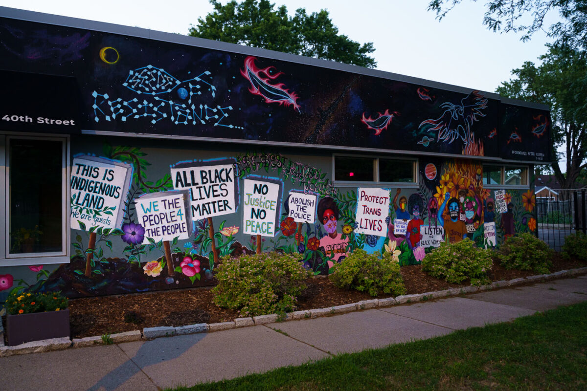 A mural in South Minneapolis. The mural shows signs reading “All Black Lives Matter” “No Justice No Peace”.