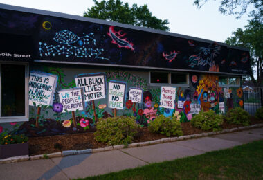 A mural in South Minneapolis. The mural shows signs reading “All Black Lives Matter” “No Justice No Peace”.