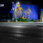 A mural on the side of a chiropractor's office in Minneapolis. "This Is Our City" written on boards at the gas station next door.