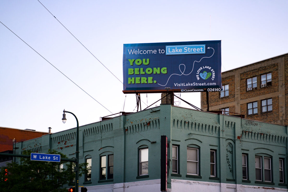 A billboard at Lake Street and Lyndale Ave in Uptown Minneapolis reading "Welcome to Lake Street. You belong here."