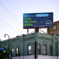 A billboard at Lake Street and Lyndale Ave in Uptown Minneapolis reading "Welcome to Lake Street. You belong here."