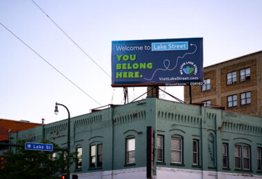 A billboard at Lake Street and Lyndale Ave in Uptown Minneapolis reading "Welcome to Lake Street. You belong here."