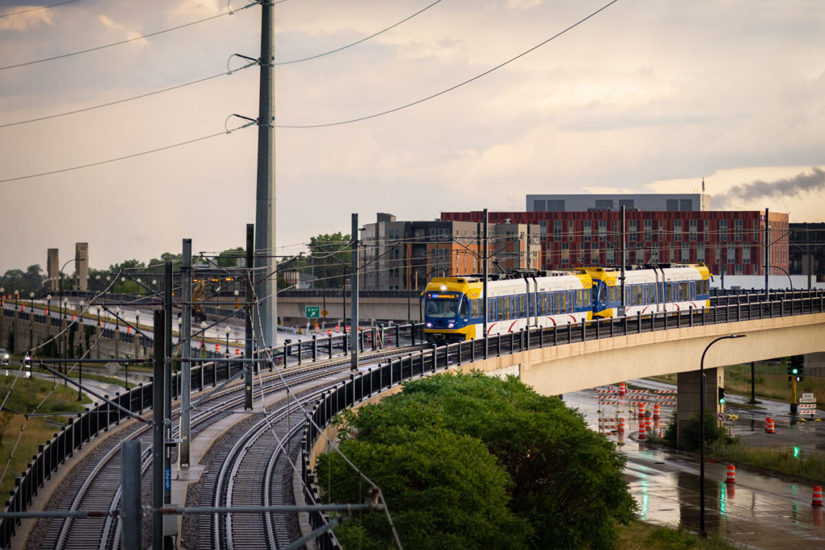 A Metro Transit Blue Line light rail train operates on an elevated track in Minneapolis. Opened in 2004, the Blue Line connects Minneapolis and Saint Paul, with extensions serving the Minneapolis-Saint Paul International Airport and northern suburbs. This elevated segment provides a dedicated right-of-way, ensuring efficient transit operations above street traffic. The light rail system is a crucial element of public transportation in the Twin Cities, linking residential areas with business districts and cultural attractions.