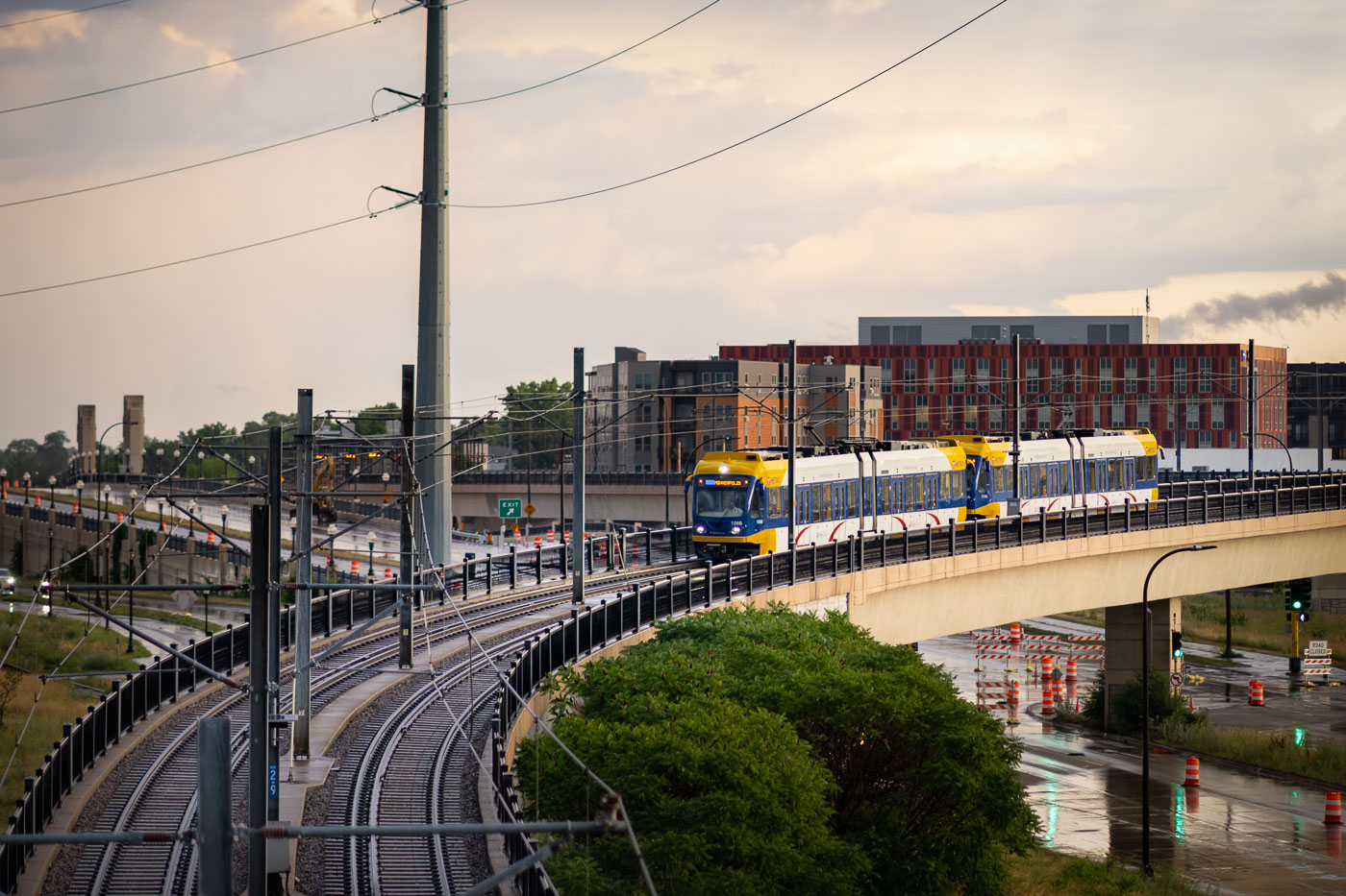 A Metro Transit Blue Line light rail train operates on an elevated track in Minneapolis. Opened in 2004, the Blue Line connects Minneapolis and Saint Paul, with extensions serving the Minneapolis-Saint Paul International Airport and northern suburbs. This elevated segment provides a dedicated right-of-way, ensuring efficient transit operations above street traffic. The light rail system is a crucial element of public transportation in the Twin Cities, linking residential areas with business districts and cultural attractions.