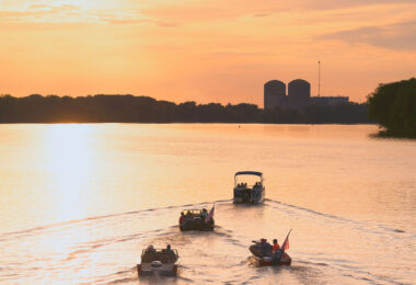 Boaters on the Mississippi River driving towards the Prairie Island Nuclear Generating Plant. Treasure Island Resort & Casino, which is just past the plant, lit off it's annual 4th of July fireworks at dusk.