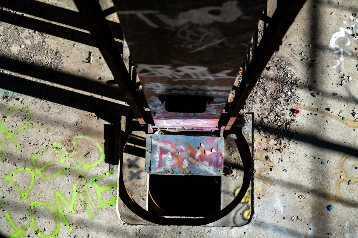 Graffitied metal box with pink and blue markings inside the abandoned Fruen Mill in Minneapolis.