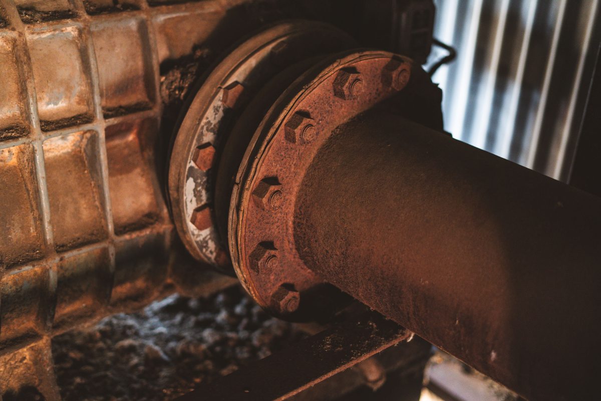 Rusted brake assembly with decorative cast iron flanges inside the abandoned Fruen Mill in Minneapolis.