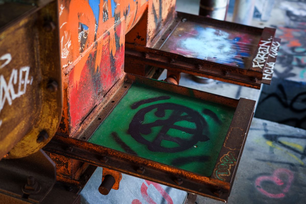 Graffitied metal box with green symbol inside the abandoned Fruen Mill, Minneapolis.