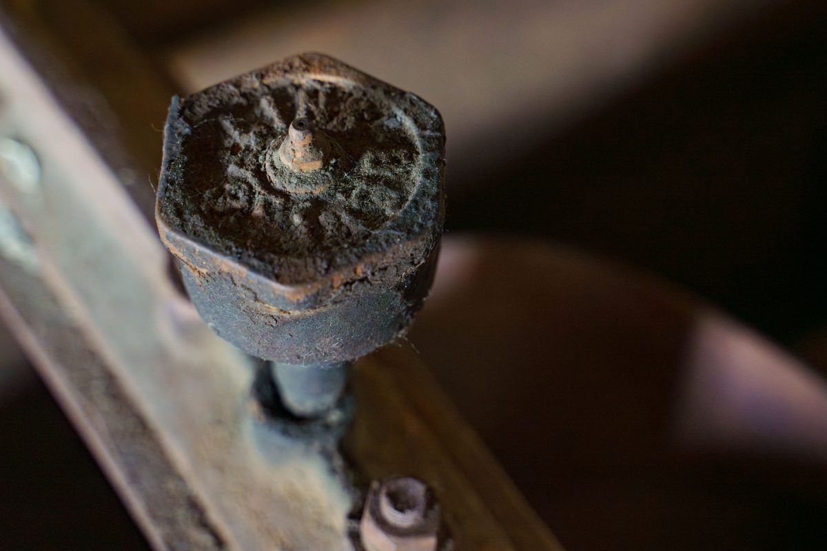 Rusted hexagonal bolt head on deteriorated metal surface inside abandoned Fruen Mill, Minneapolis.