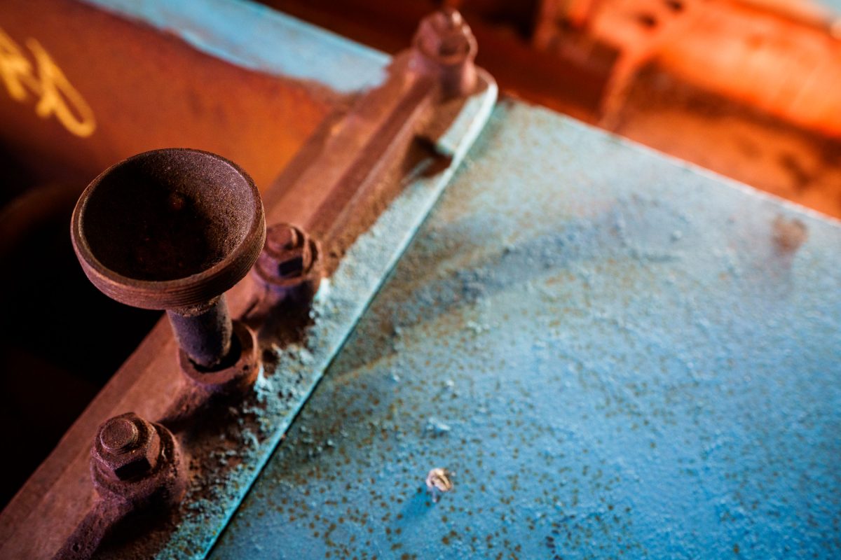 Rusted cast iron valve on deteriorated metal surface inside abandoned Fruen Mill, Minneapolis.