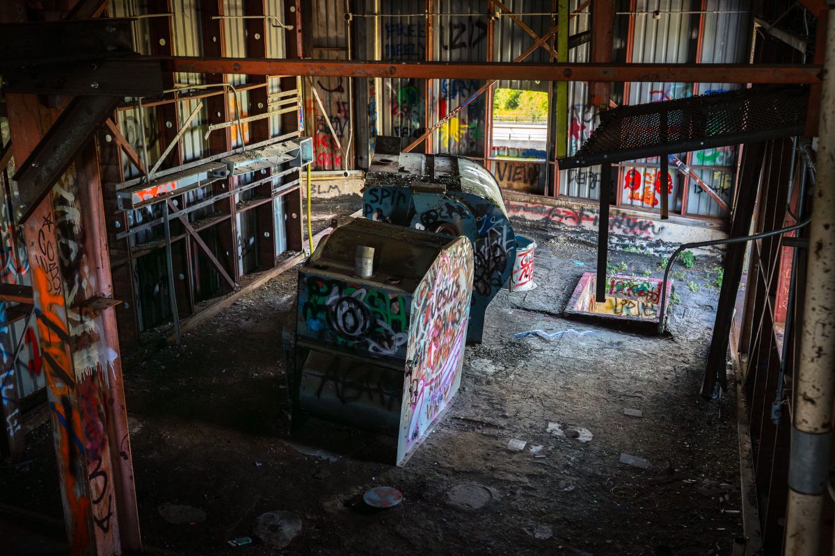 Abandoned Fruen Mill interior in Minneapolis with graffitied machinery and metal structural framework.