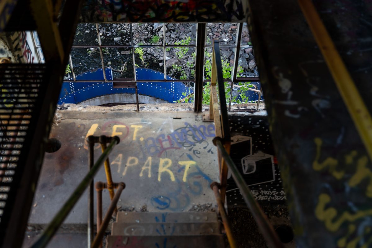 Graffiti-covered floor and yellow metal beam inside the abandoned Fruen Mill industrial complex in Minneapolis.