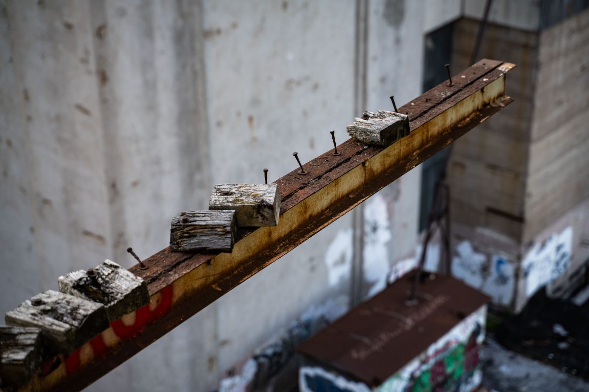 Rusted metal beam with wooden blocks and nails inside the abandoned Fruen Mill in Minneapolis.