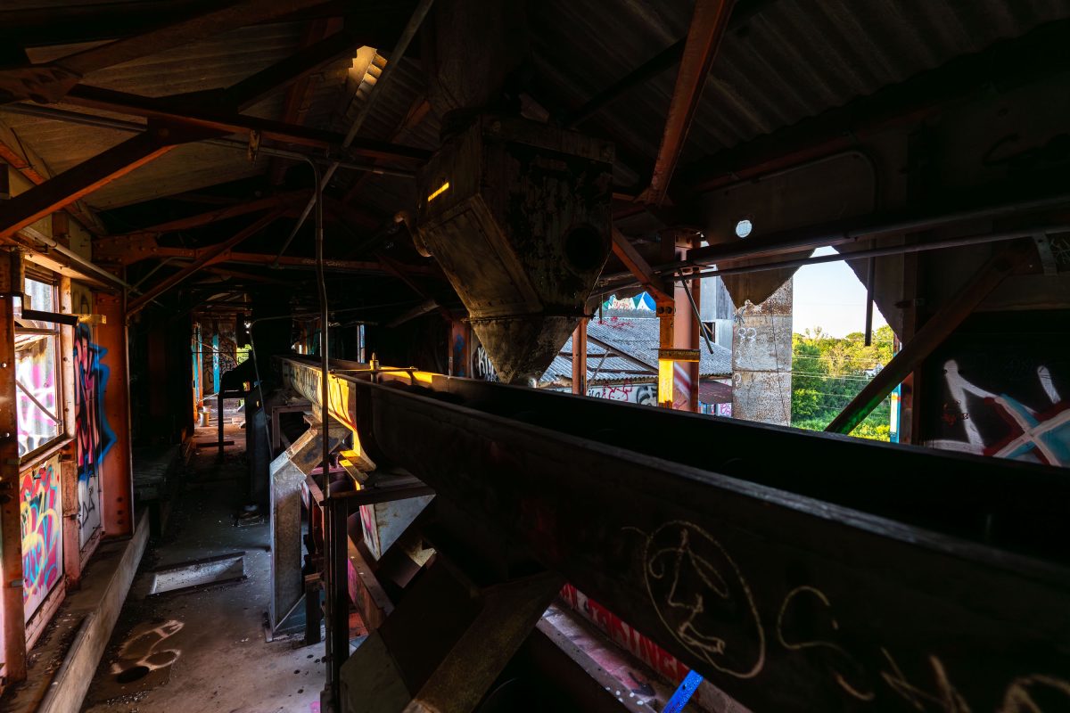 Interior of abandoned Fruen Mill in Minneapolis showing rusted industrial equipment and graffiti-covered metal structures.