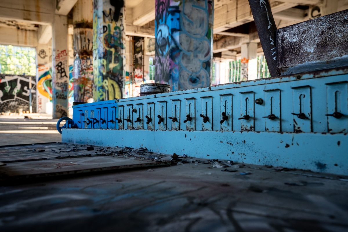 Painted blue metal beam with repeated decorative cutouts inside abandoned Fruen Mill in Minneapolis.