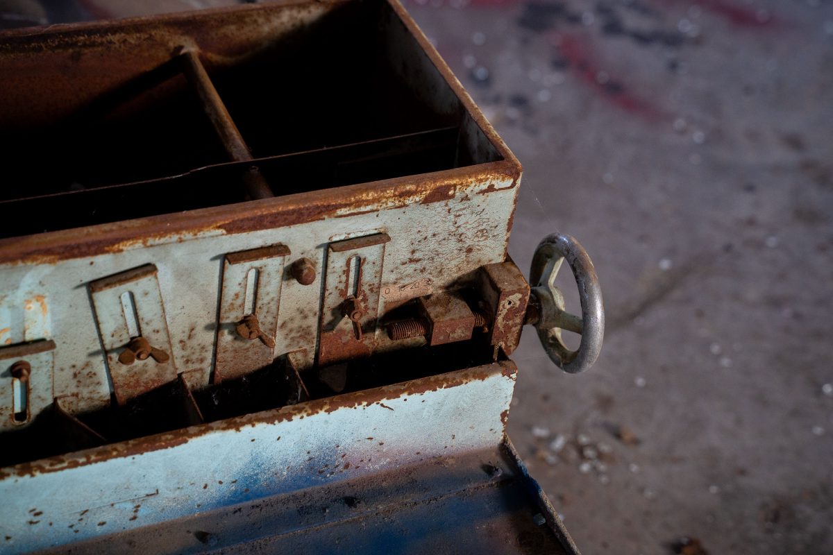 Rusted metal pulley and control mechanism inside the abandoned Fruen Mill industrial complex in Minneapolis.