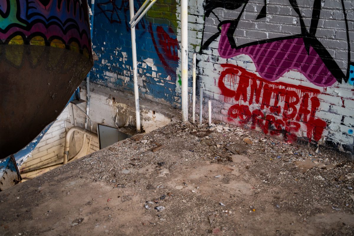 Deteriorating basement space at abandoned Fruen Mill in Minneapolis with colorful graffiti on brick walls.