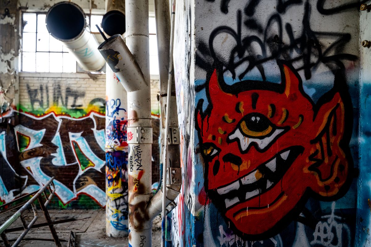 Red demon graffiti art on wall inside abandoned Fruen Mill in Minneapolis.