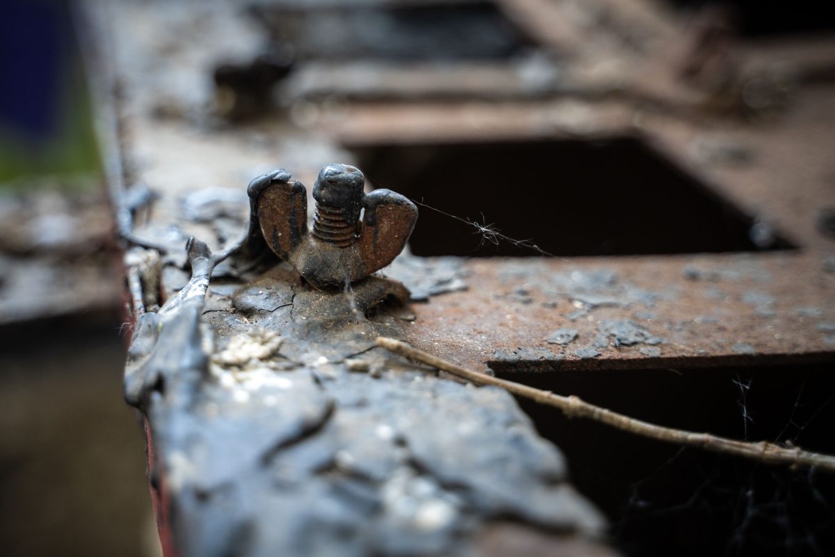 Rusted cast iron machinery component with decorative flanges inside the abandoned Fruen Mill in Minneapolis.