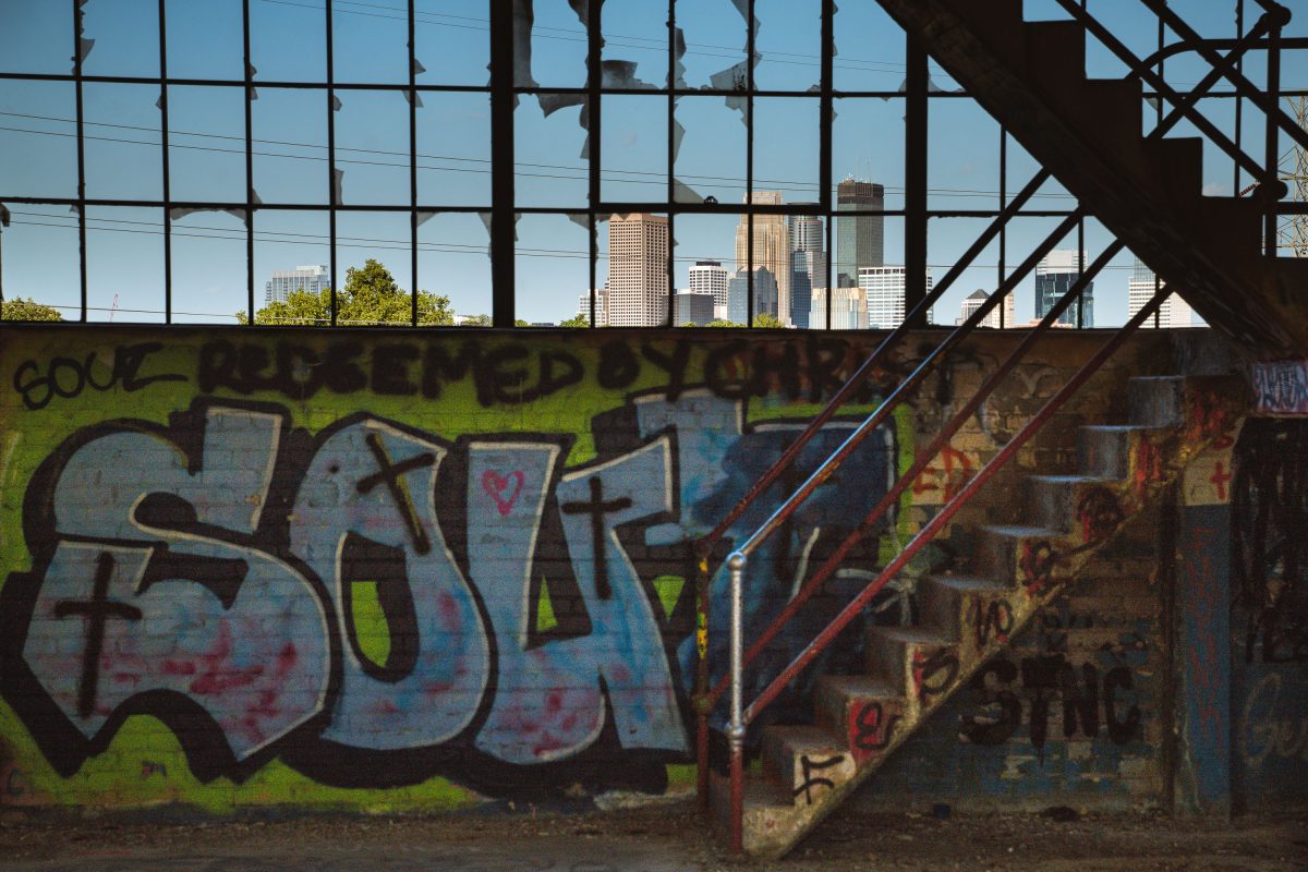 Graffitied industrial staircase and rusted metal framework inside the abandoned Fruen Mill in Minneapolis.