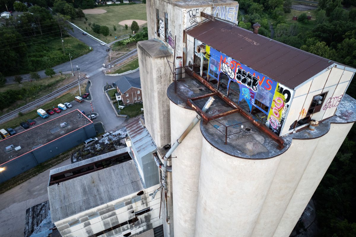 Aerial view of the abandoned Fruen Mill rooftop in Minneapolis with colorful graffiti and deteriorating structures.