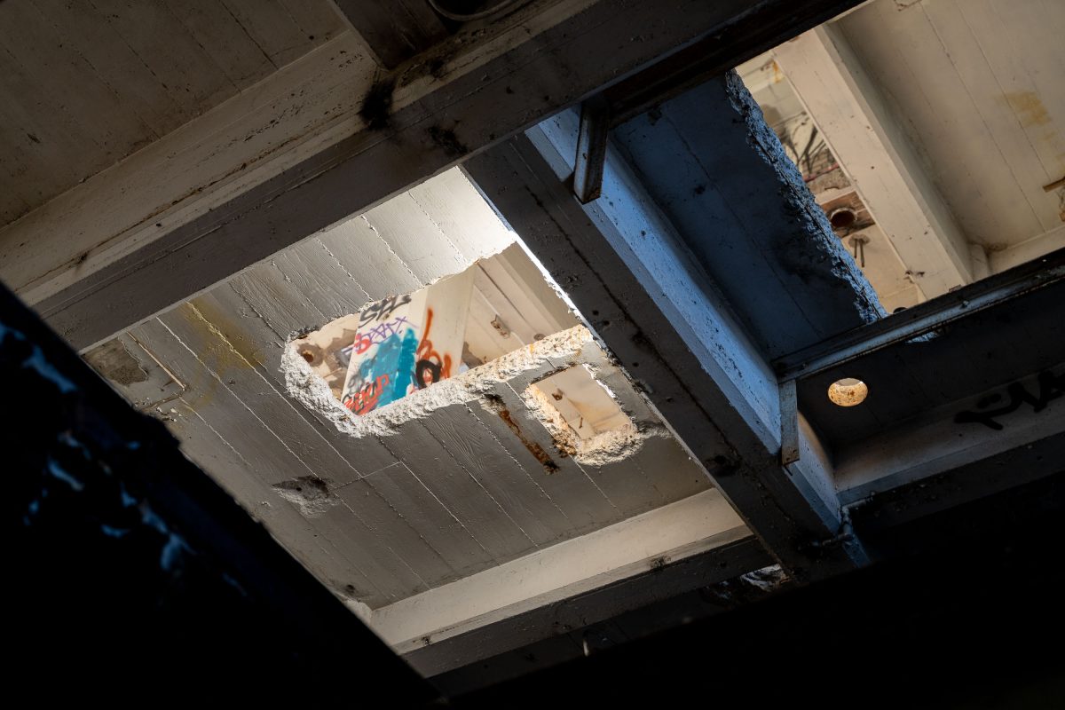 Graffitied ceiling openings reveal industrial machinery inside the abandoned Fruen Mill in Minneapolis.