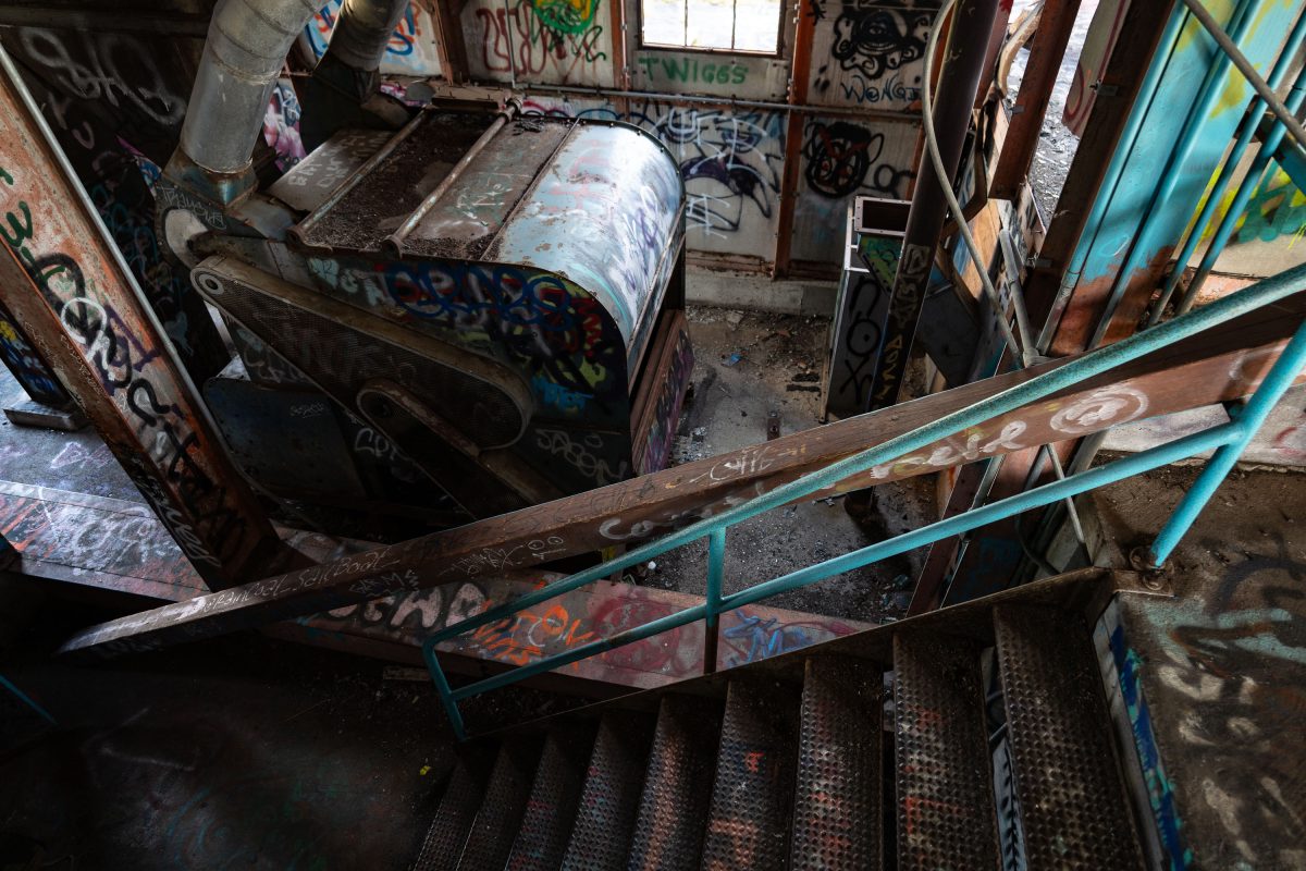 Graffitied industrial equipment and metal railings inside the abandoned Fruen Mill in Minneapolis.