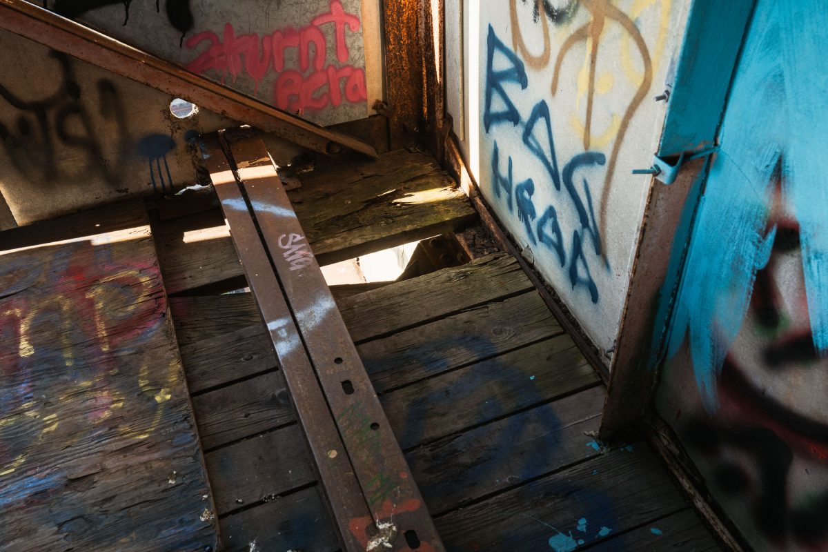 Interior stairway of abandoned Fruen Mill in Minneapolis with graffitied walls and rusted metal railing.