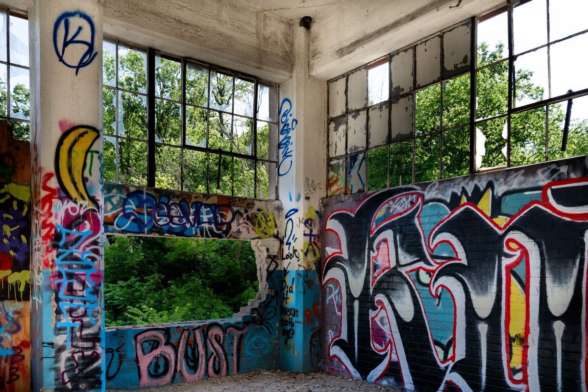 Abandoned Fruen Mill interior in Minneapolis with colorful graffiti on concrete walls and industrial windows.