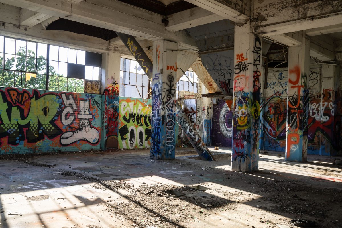 Abandoned Fruen Mill interior in Minneapolis with graffitied industrial columns and deteriorated concrete floor.
