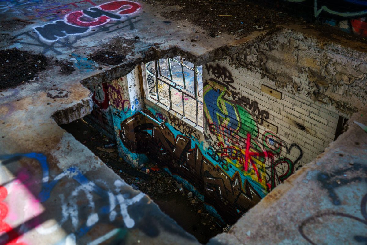 Abandoned basement room at Fruen Mill in Minneapolis with colorful graffiti covering brick walls and windows.