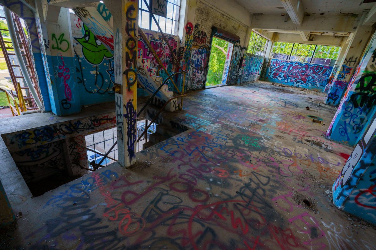 Abandoned interior of Fruen Mill in Minneapolis covered with colorful graffiti on walls and floor.