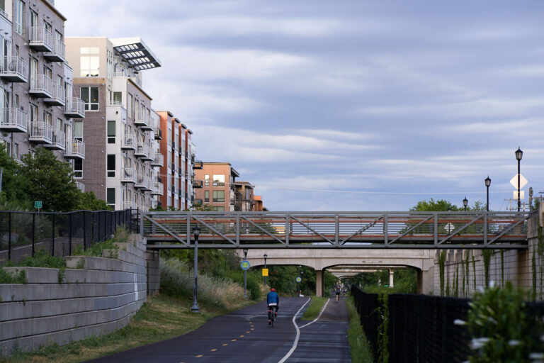 Midtown Greenway, Minneapolis: Pedestrian Bridge and Apartments 4 The Midtown Greenway in Minneapolis is a 5.5-mile-long trail developed on a former railroad corridor, providing a vital artery for cyclists and pedestrians through the city. Adjacent apartment buildings, constructed in recent years, demonstrate the integration of modern residential development with the trail's active use. A pedestrian bridge spans the greenway, connecting neighborhoods and enhancing access to this popular urban path.