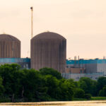 The twin concrete containment domes pictured here belong to the Prairie Island Nuclear Generating Plant, located along the Mississippi River just northwest of Red Wing, Minnesota. Operated by Xcel Energy, the facility houses two pressurized-water reactors that began commercial operation in the early 1970s. The domed structures serve as reinforced containment buildings, designed to house the reactor vessels and critical safety systems.

Set against the river and surrounded by dense tree cover, the plant sits adjacent to the Prairie Island Indian Community, whose proximity has been central to public discussions about nuclear safety, spent-fuel storage, and long-term energy planning in Minnesota. The low evening light in this image highlights the muted textures of the domes and the teal-panel cladding of the turbine and support buildings, offering a clear view of one of the state’s most prominent pieces of energy infrastructure.