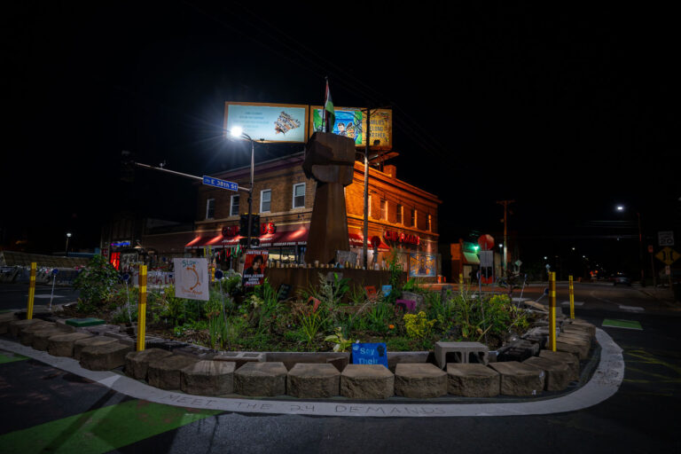 Fist in the middle of George Floyd Square in August 2022 1 As the city begins “Monthly learning tables” as part of its “38th & Chicago Re-Envisioned” project, more than a year after streets were reopened to vehicles, the ask from those at George Floyd Square continues to be the same as it has been since August 7, 2020: Meet the demands.