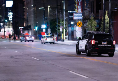 A Minneapolis police squad car drives down Hennepin Avenue in Downtown Minneapolis.