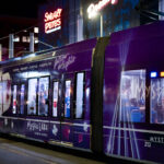 A Mystic Lake casino wrapped light rail train at the Warehouse District-Hennepin LRT station during a Twin's game.