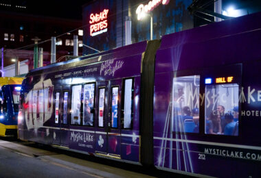 A Mystic Lake casino wrapped light rail train at the Warehouse District-Hennepin LRT station during a Twin's game.
