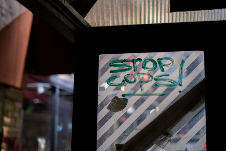 Stop Cops! Graffiti 3 Stop Cops! written on a former bus shelter at George Floyd Square.