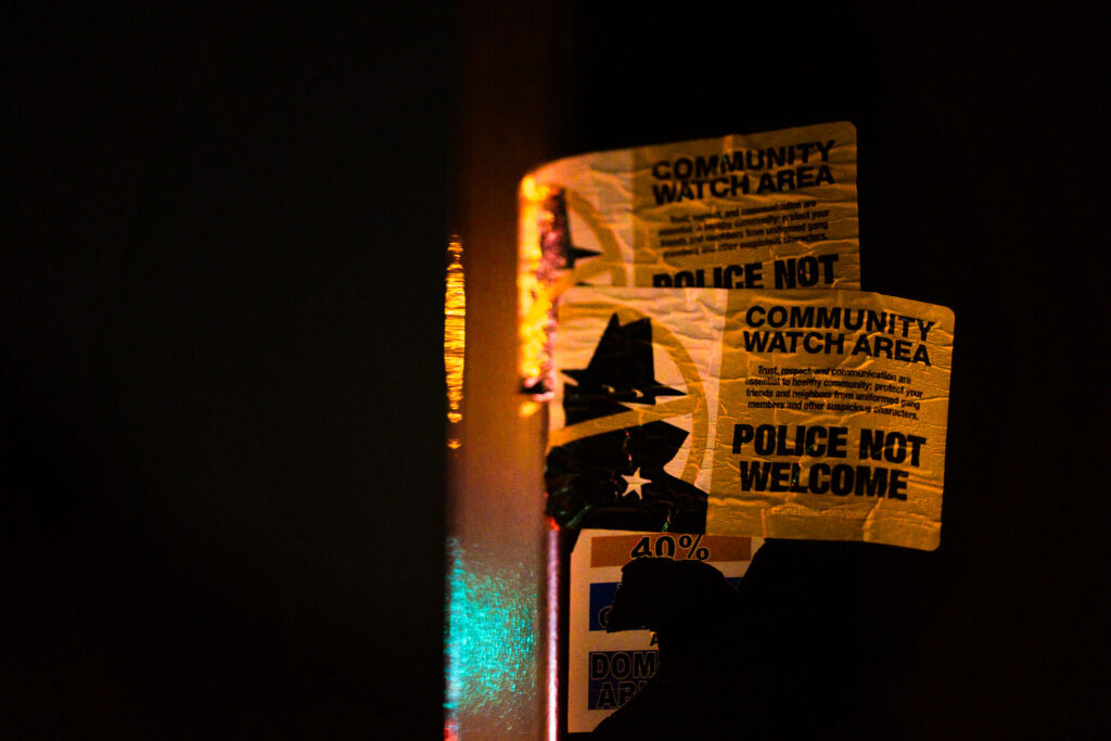 A crimethinc sticker "Police Not Welcome" on a street pole in Minneapolis.