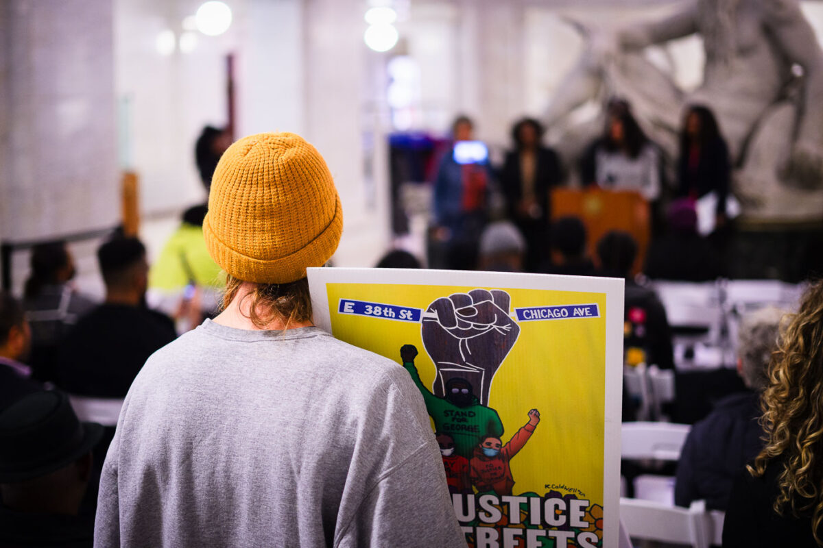 A protester holds up a sign reading “No Justice No Streets” as the Mayor Jacob Frey proclaims it George Floyd Day. It would have been Floyd’s 49th birthday.