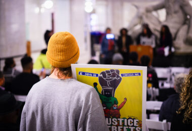 A protester holds up a sign reading “No Justice No Streets” as the Mayor Jacob Frey proclaims it George Floyd Day. It would have been Floyd’s 49th birthday.