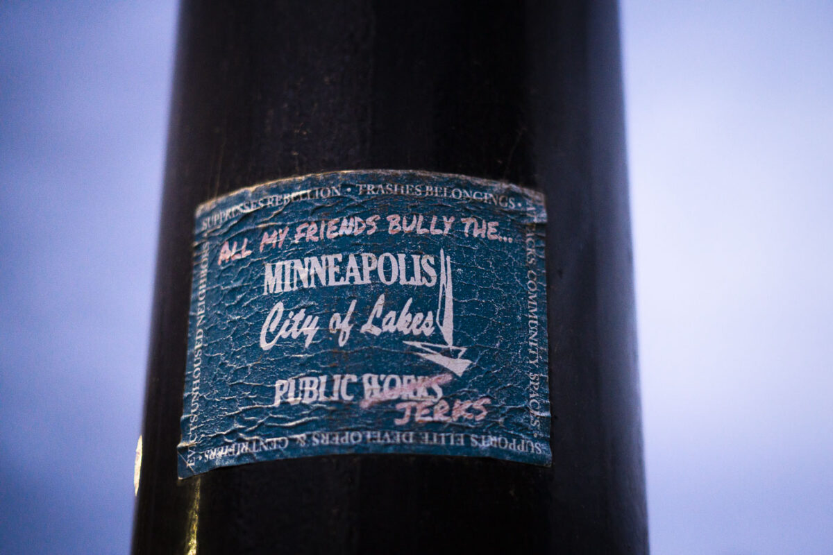 "All my friends bully the Minneapolis Public Works(Jerks)" sticker on a light pole. In response to Public Works participating in encampment clearings.