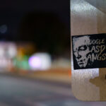 A sticker on a Minneapolis signpost references long-running allegations surrounding deputy “gangs” within the Los Angeles County Sheriff’s Department (LASD). Civil rights groups, journalists, and county oversight bodies have documented concerns for decades about informal deputy subgroups—some using matching tattoos or symbols—that critics say foster misconduct, retaliation, and internal loyalty structures.

Seeing a reference to those controversies on a street sign in Minneapolis reflects how national policing debates and accountability issues often circulate far beyond their place of origin, with artists and activists using stickers, posters, and small-scale street graphics to raise awareness or prompt online searches.