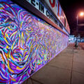A new mural from Jimmy Longoria wraps around the Chicago-Lake Liquors building and covering the front metal shutters.