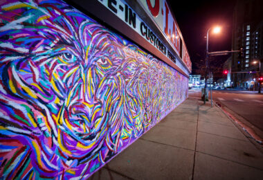 A new mural from Jimmy Longoria wraps around the Chicago-Lake Liquors building and covering the front metal shutters.