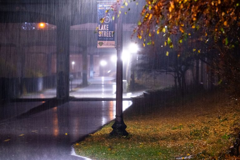 Lake Street Sign at Midtown Greenway, South Minneapolis 2 Lake Street sign illuminated at night during rainfall on the Midtown Greenway in Minneapolis.