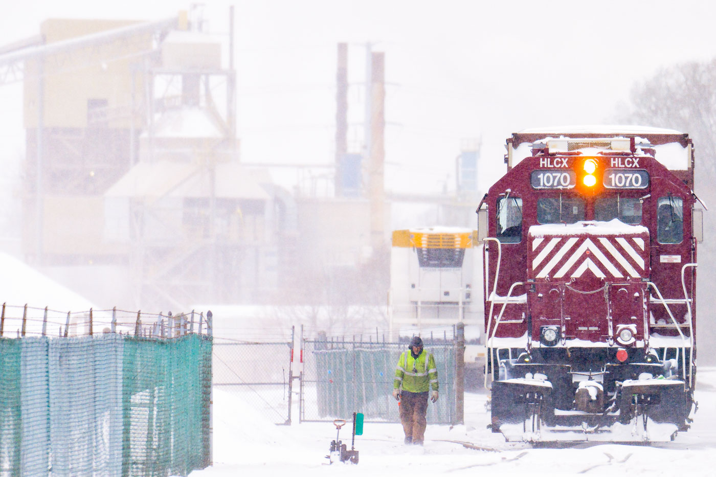 Rail worker next to a train during a snowstorm