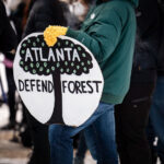 rotesters gather near Hennepin Avenue and Lake Street in Minneapolis to honor Manuel “Tort” Teran, who was killed during a long-running protest effort in the South River Forest near Atlanta. Demonstrators held signs and marched in solidarity with organizers nationwide, linking the Atlanta case to local histories of protest in Minneapolis. The group paused at Lake Street and Girard Avenue, the site where Deona Marie was killed on June 13, 2021, during demonstrations following the police shooting of Winston Smith. The march connected these separate events through a shared emphasis on community memory, public accountability, and the long-term impacts of protest-related violence.