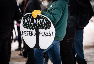 rotesters gather near Hennepin Avenue and Lake Street in Minneapolis to honor Manuel “Tort” Teran, who was killed during a long-running protest effort in the South River Forest near Atlanta. Demonstrators held signs and marched in solidarity with organizers nationwide, linking the Atlanta case to local histories of protest in Minneapolis. The group paused at Lake Street and Girard Avenue, the site where Deona Marie was killed on June 13, 2021, during demonstrations following the police shooting of Winston Smith. The march connected these separate events through a shared emphasis on community memory, public accountability, and the long-term impacts of protest-related violence.